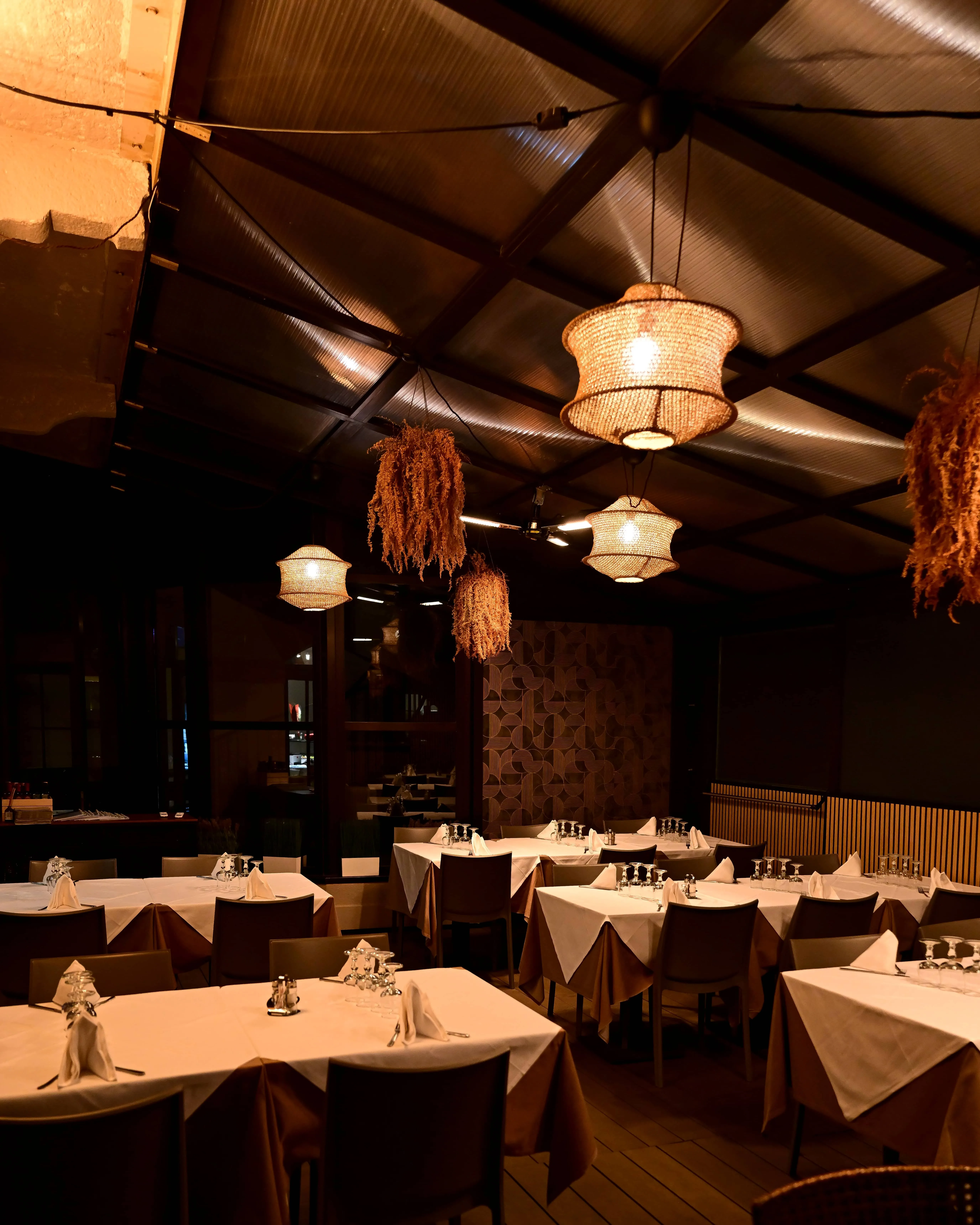 Sala del ristorante con travi in legno e lampade di vimini